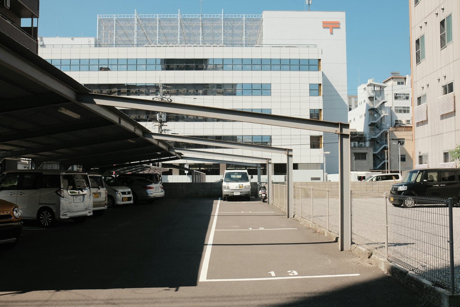 Cars parked under a modern carport on a sunny day